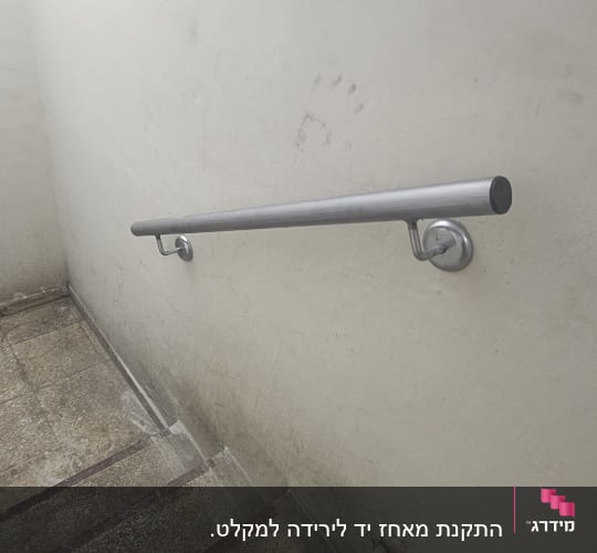 מעקה מתכת על קיר מדרגות